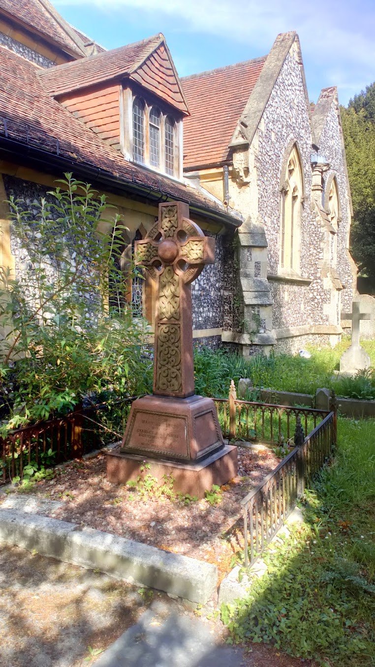 A carved Celtic cross memorial in the churchyard