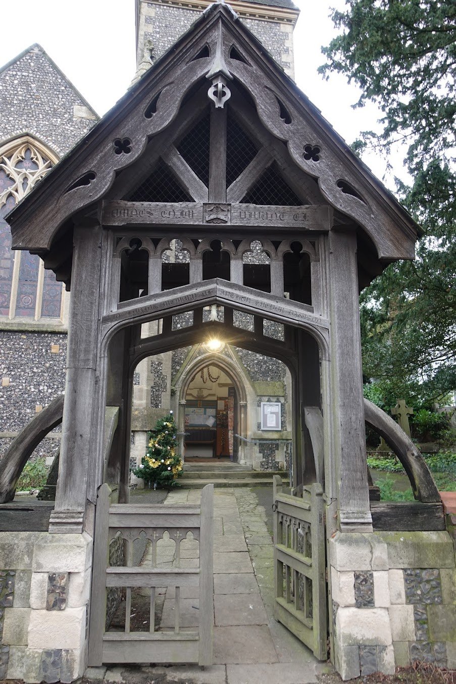 The lychgate framing the church entrance, with a Christmas tree, in Advent