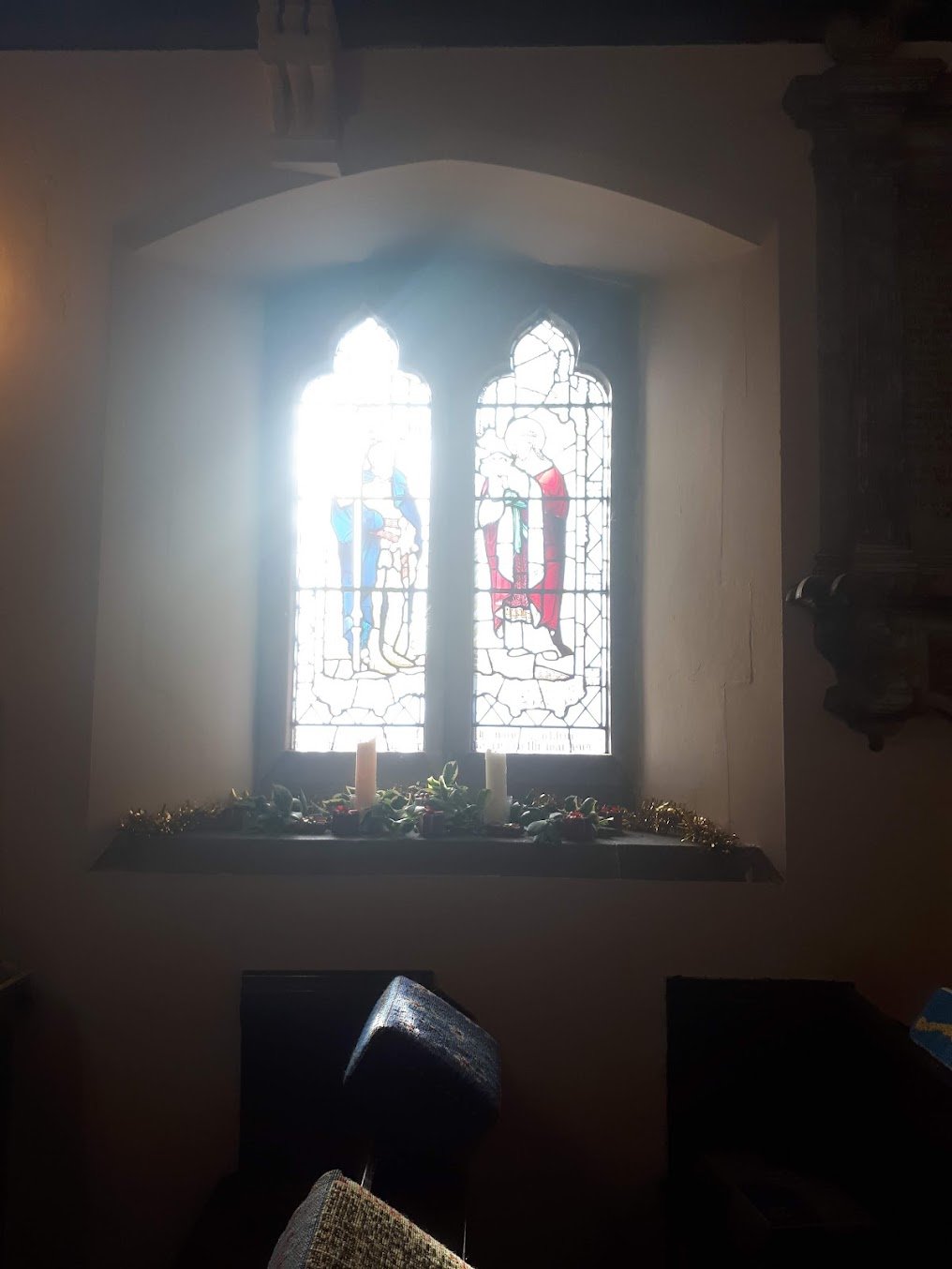 Sunlight streaming through a stained-glass window inside St Nicholas Church